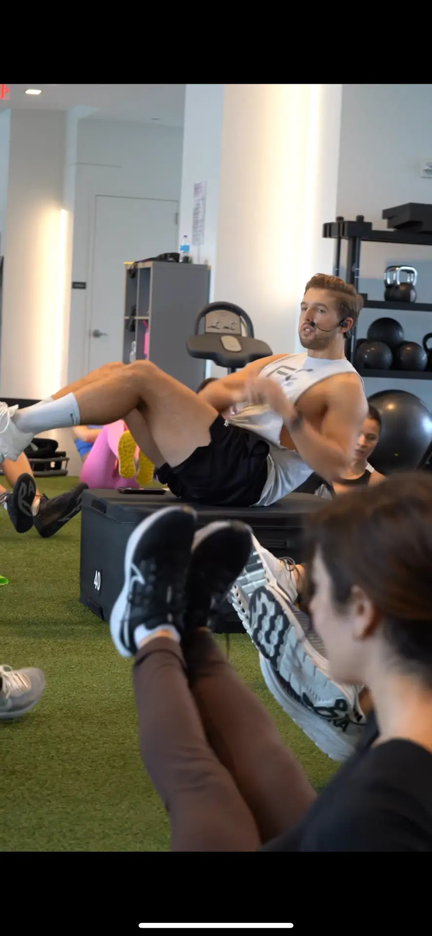 Anthony Perri leading a group core circuit on turf